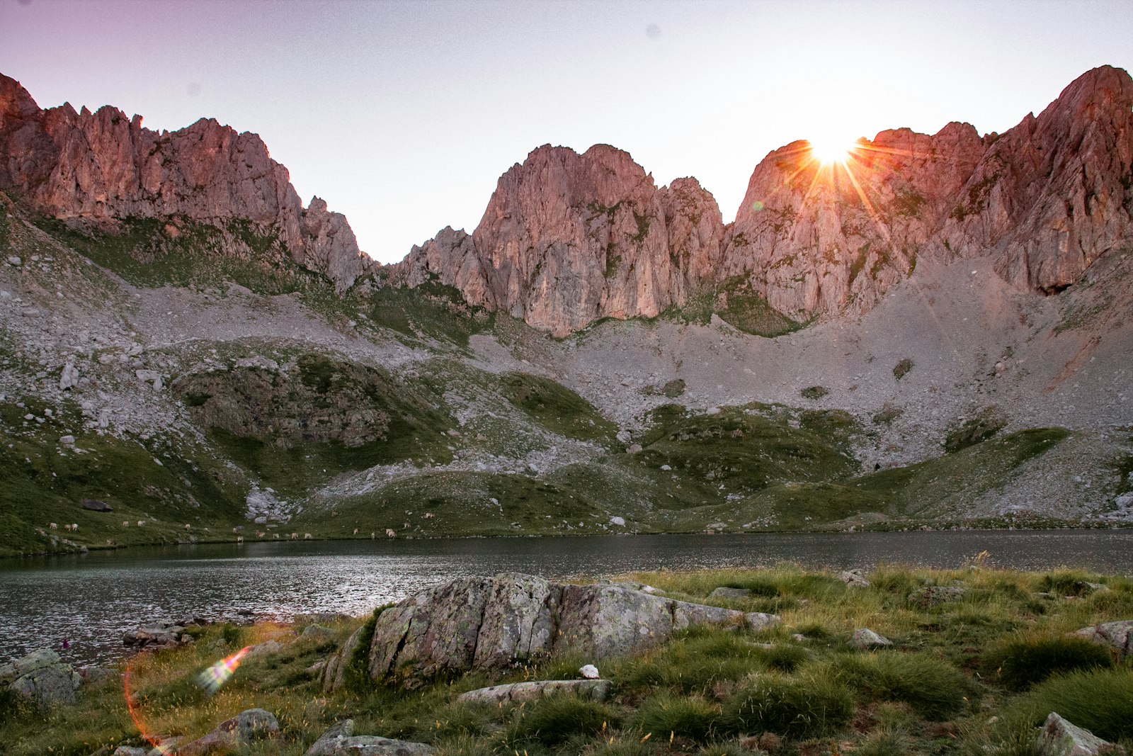 Aiguilles rocheuses rosies par le soleil au-dessus d’un lac