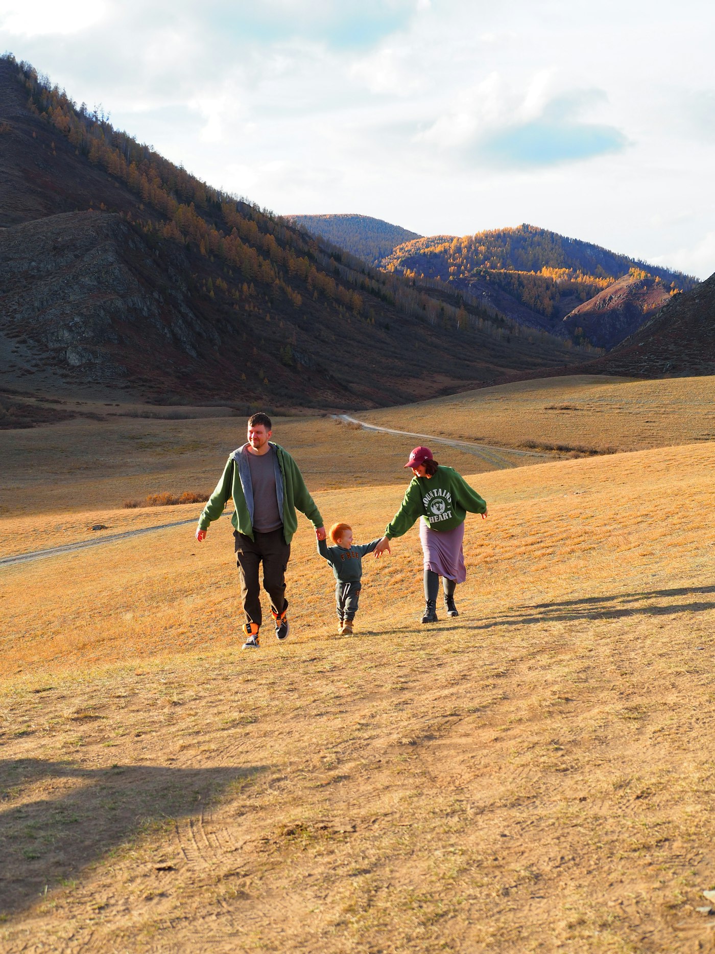 Parents et enfant marchant main dans la main sur une estive