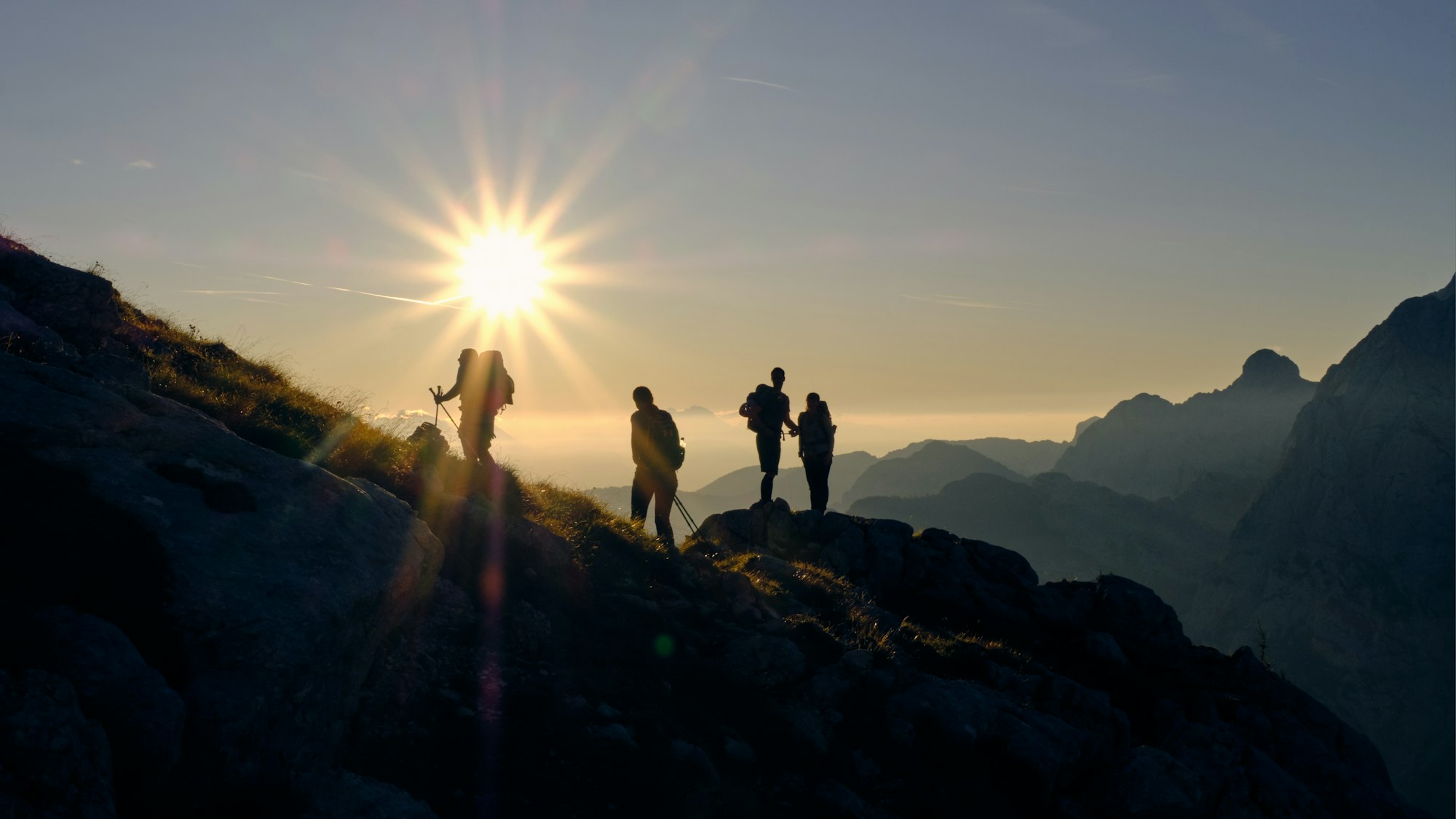 Randonneurs au sommet face au soleil levant